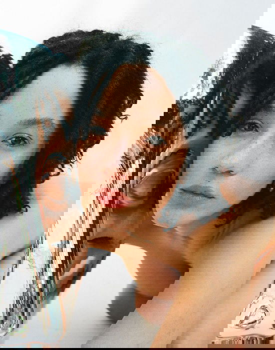 Portrait of a woman with her face against a reflective surface