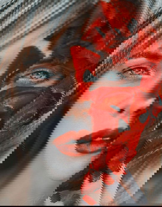 Close portrait of woman with half flower mask