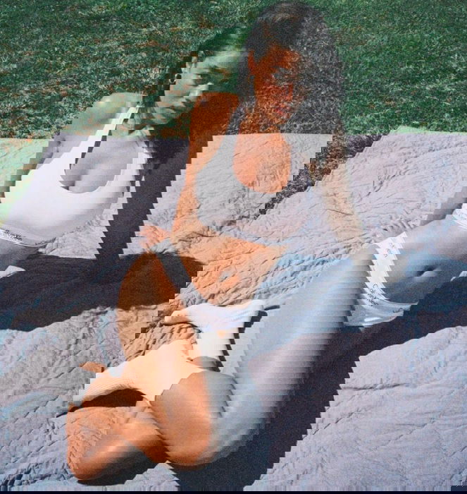 Woman sitting on a blanket outside