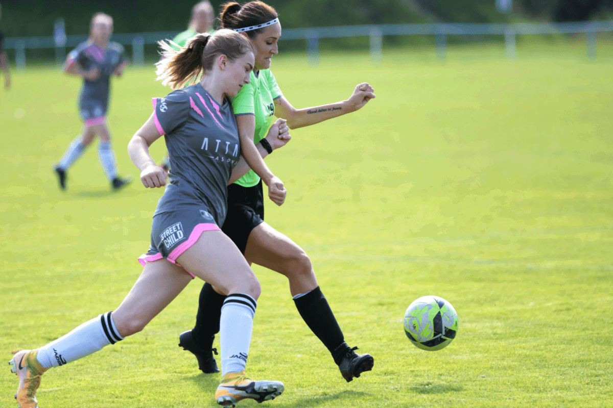 Two soccer players challenging for the ball