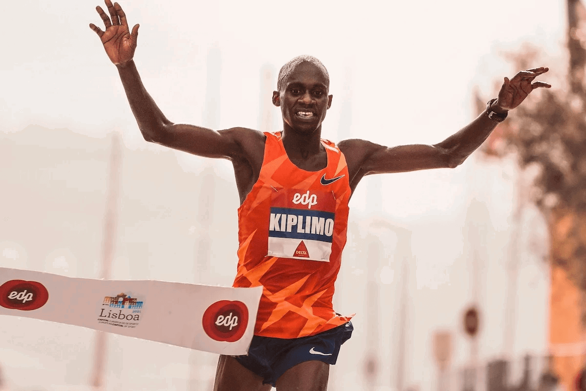 A male athlete running and celebrating his victory.